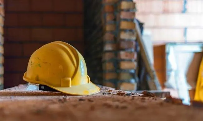 Immagine di un cantiere con un casco per dire quanto sia importante la sicurezza per evitare un altro operaio morto sul lavoro