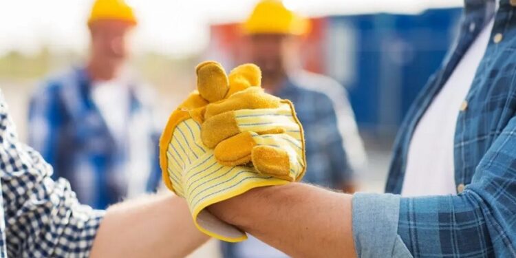 Nell'immagine due lavoratori che si stringono la mano