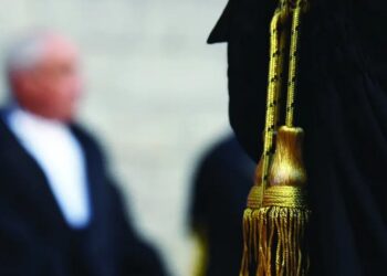 Nell'immagine un avvocato e il dettaglio della toga