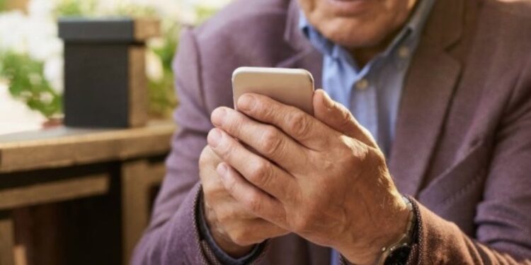 Un anziano mentre guarda il telefono