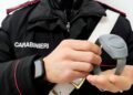 Un carabiniere mentre mostra il braccialetto elettronico