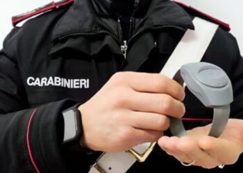 Un carabiniere mentre mostra il braccialetto elettronico