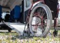 Una sedia a rotelle ed un mezzo adibito al trasporto per le persone con disabilità