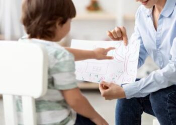 Una psicologa intenta ad interagire con un piccolo paziente