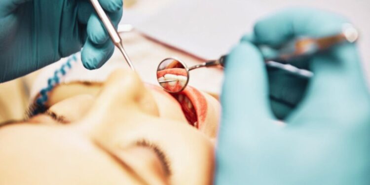 Un dentista interviene su una paziente