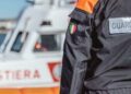 Un militare della Guardia costiera e sullo sfondo una motovedetta