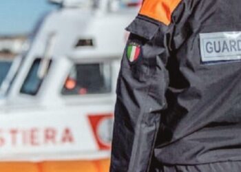 Un militare della Guardia costiera e sullo sfondo una motovedetta