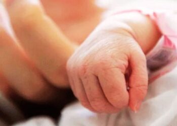 la mano di un neonato e quella di un adulto