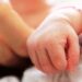la mano di un neonato e quella di un adulto