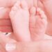 I piedini di un neonato tra le mani di una mamma