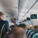 L'interno di un aereo con una hostess e i passeggeri