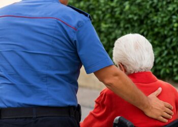 Un carabiniere aiuta una donna anziana