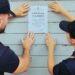 Due poliziotti affiggono i sigilli con il provvedimento di chiusura per 15 giorni