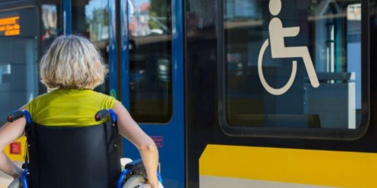 Una persona disabile intenta a prendere un treno