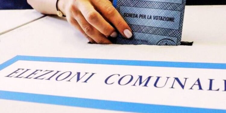Un elettore imbuca la scheda elettorale nell'urna dedicata alle elezioni comunali