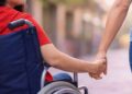 Una madre con una figlia disabile in sedia a rotelle