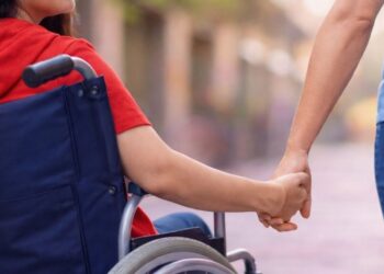 Una madre con una figlia disabile in sedia a rotelle