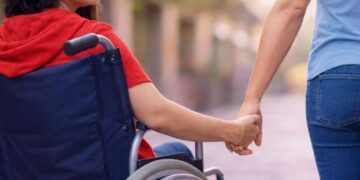 Una madre con una figlia disabile in sedia a rotelle