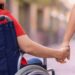Una madre con una figlia disabile in sedia a rotelle
