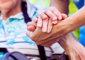 Una signora anziana assistita da un oss