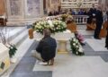 l padre delle tre vittime in ginocchio accanto alla bara del figlio più piccolo (Foto Ansa)