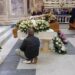 l padre delle tre vittime in ginocchio accanto alla bara del figlio più piccolo (Foto Ansa)