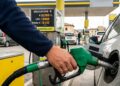 Una pompa di benzina, con una persona che fa rifornimento alla propria auto