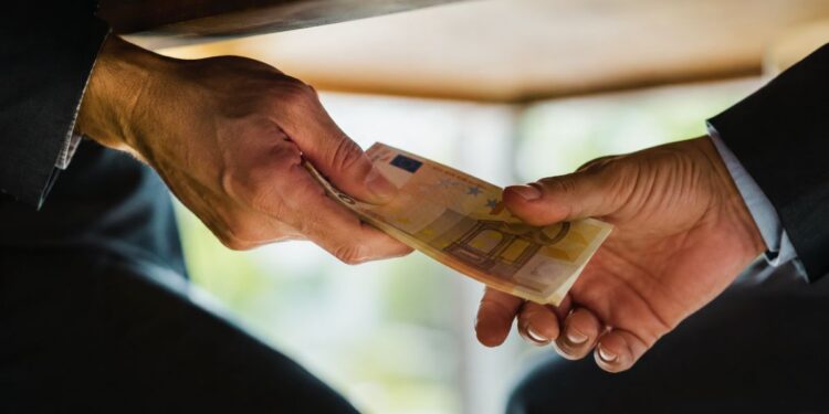 Uno scambio di soldi che rappresenta la corruzione