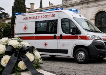 Una ambulanza e dei fiori in segno di lutto