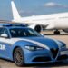 Una pattuglia della Polizia di Stato con sullo sfondo un aereo