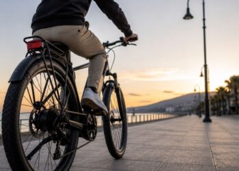 Un uomo in sella ad una bicicletta elettrica su un lungomare