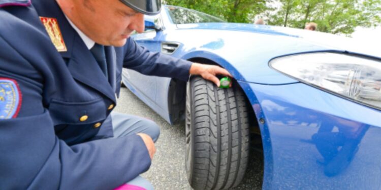 Un agente della Polizia di Stato controlla la ruota di una vettura