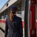Un capotreno accanto a un treno in partenza in una stazione