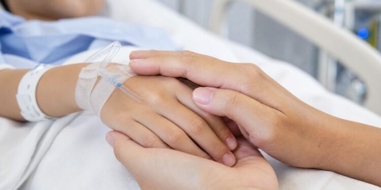Un bambino ricoverato in ospedale, mano nella mano