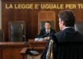 Un avvocato con la toga di fronte a un giudice durante un processo in un'aula di tribunale
