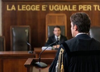 Un avvocato con la toga di fronte a un giudice durante un processo in un'aula di tribunale