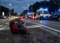 Un casco sull'asfalto a seguito di un incidente stradale. Sullo sfondo ambulanza e carabinieri