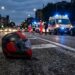 Un casco sull'asfalto a seguito di un incidente stradale. Sullo sfondo ambulanza e carabinieri