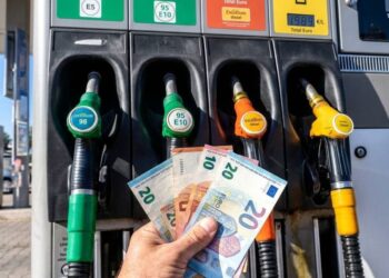 Alcune banconote euro e una pompa di benzina