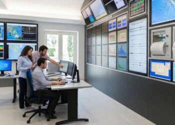 Una control room per i terremoti con studiosi intenti a controllare i sismografi e i dati