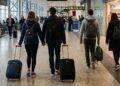 I passeggeri in aeroporto che si dirigono al gate per l'imbarco di un volo
