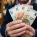 Una persona tiene in mano diversi euro