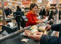 Una persona fa la spesa al supermercato, mostra pochi euro in cassa