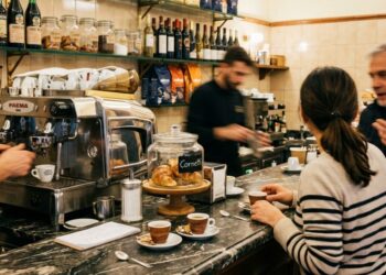 Un bar con clienti al bancone e baristi